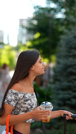 young woman traveling with luggage and drink