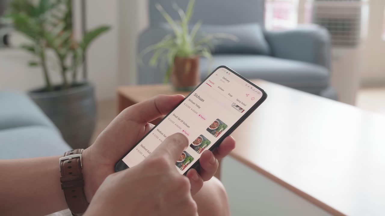 Close Up Of Man Hand Holding Smartphone And Orders Food In Online Store