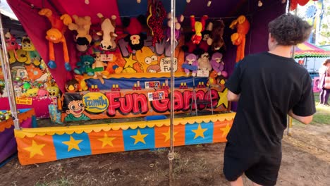 man playing ball toss game at fun fair