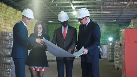 Business Team Reviewing Blueprints in a Warehouse
