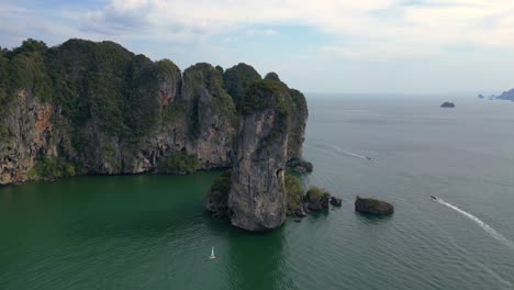 una vista impresionante de una bahía aislada con aguas turquesas, rodeada de altos acantilados cubiertos de exuberante vegetación verde
