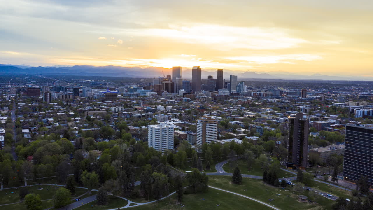 Aerial time lapse over Denver's Cheesman Park and surrounding residential area with the sun setting in the background
