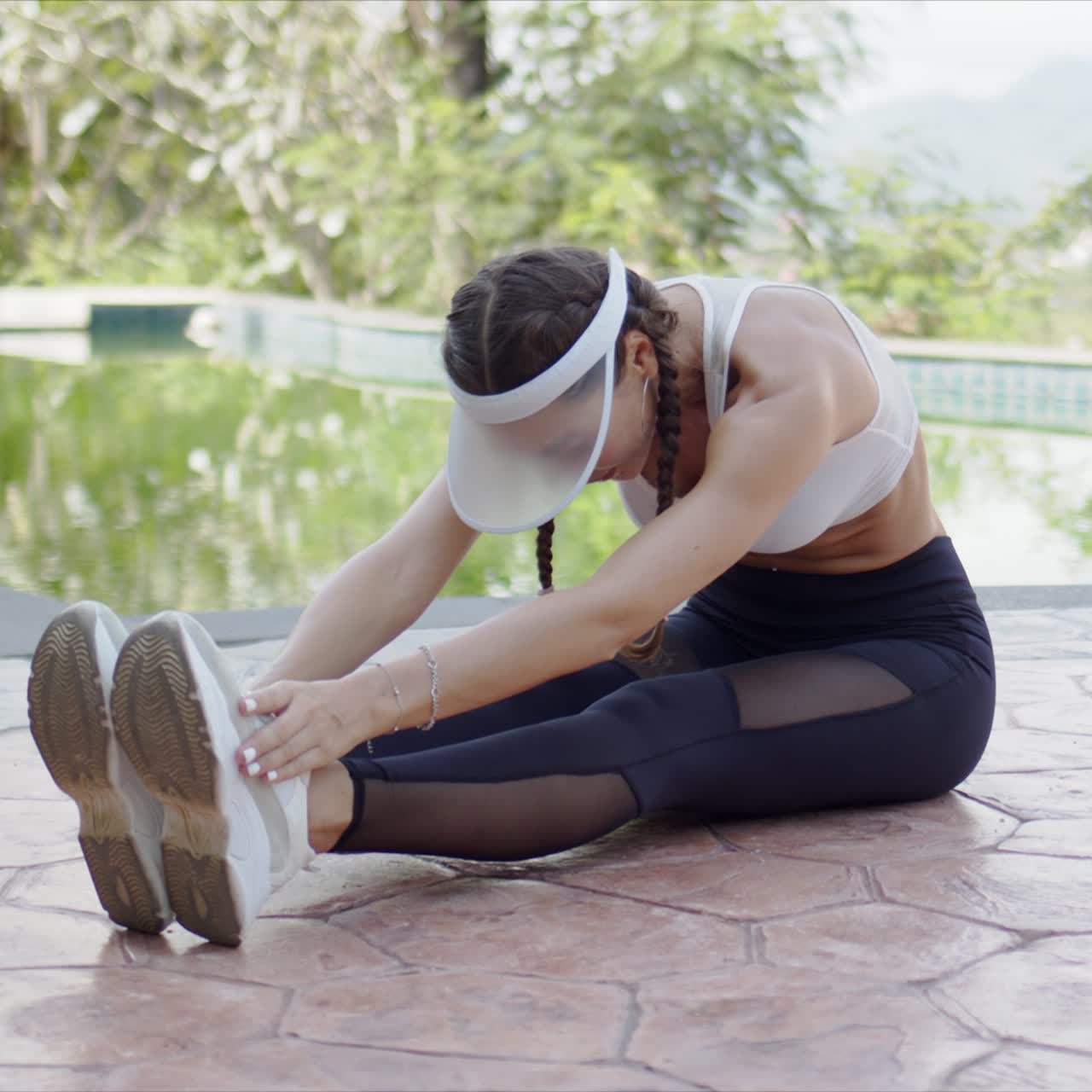 mujer delgada haciendo ejercicio junto a la piscina