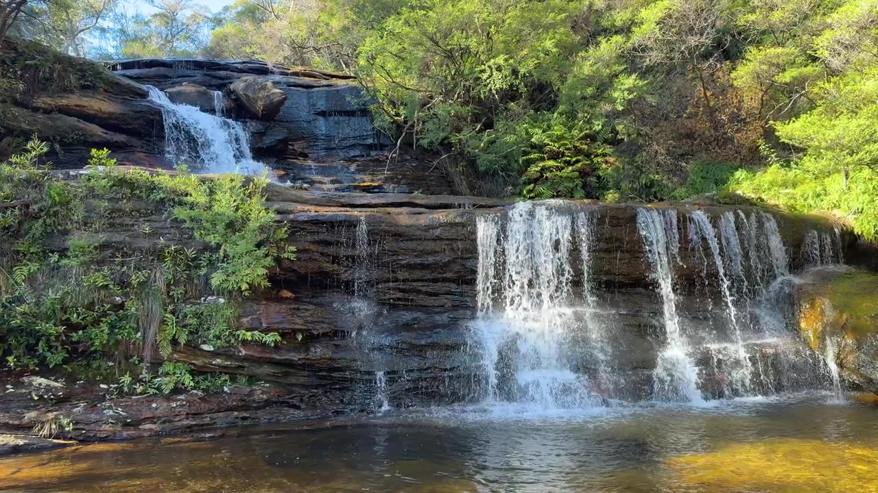 Plano geral de água fluindo sobre patamares rochosos no Parque Nacional Blue Mountains, Austrália