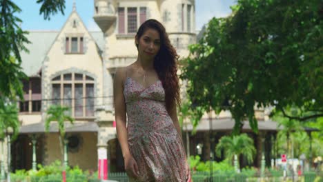 Latina-walks-in-a-park-with-hair-flowing-in-the-wind-and-a-castle-in-the-background