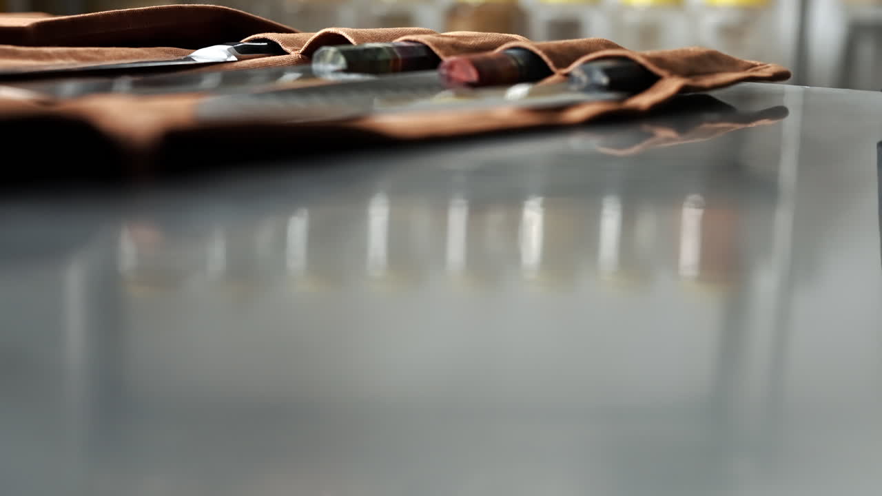 el chef saca un cuchillo de un rollo de cuero, luego lo vuelve a poner, juego de cuchillos