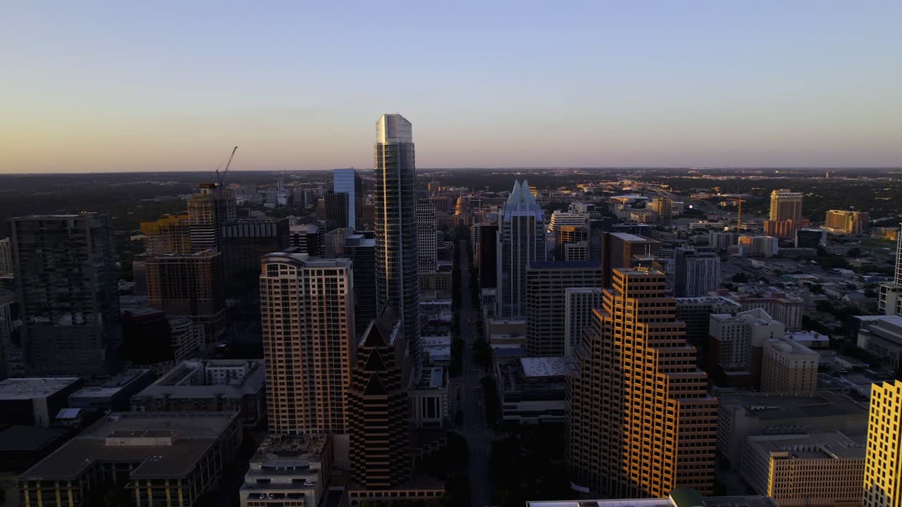 vista aérea volando entre edificios en la avenida del congreso, hacia el capitolio del estado de texas, puesta de sol en austin, estados unidos