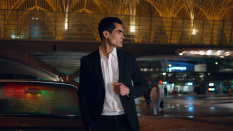 business driver waiting at night car place. elegant businessman looking asides