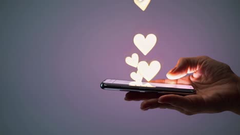 hand holding a smartphone with glowing hearts