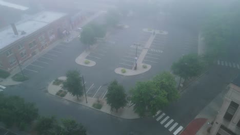 Drone-De-Alto-ángulo-Inclinado-Hacia-Arriba-A-Lo-Largo-De-Un-Estacionamiento-Vacío-Lleno-De-Niebla-En-La-Ciudad