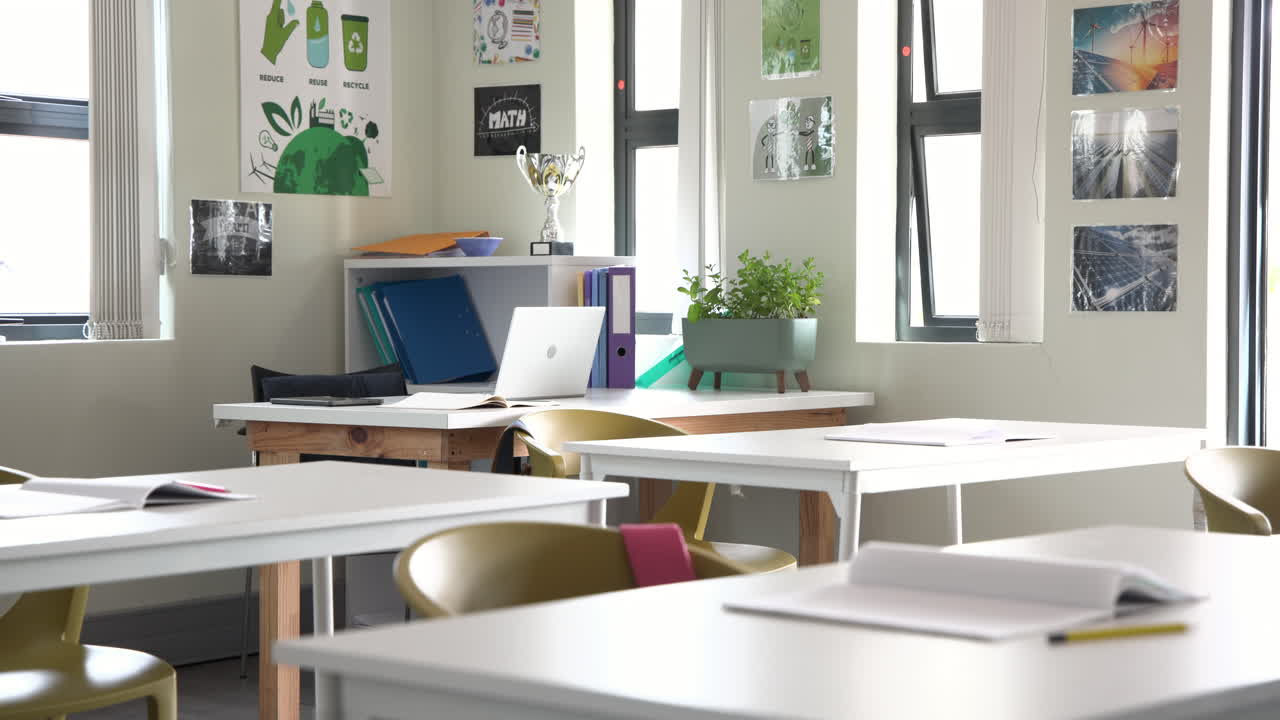 Empty classroom with open notebooks and laptop on desks, ready for multiracial students, at school