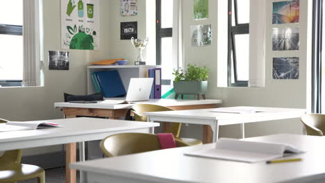 empty classroom with open notebooks and laptop on desks, ready for multiracial students, at school