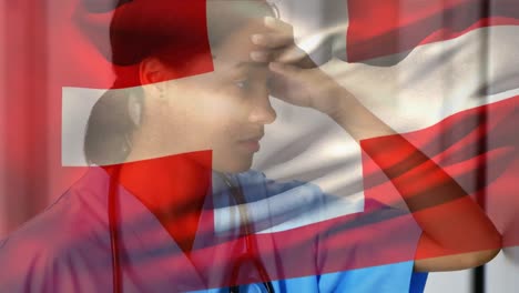 switzerland flag waving against stressed african american female health worker at hospital