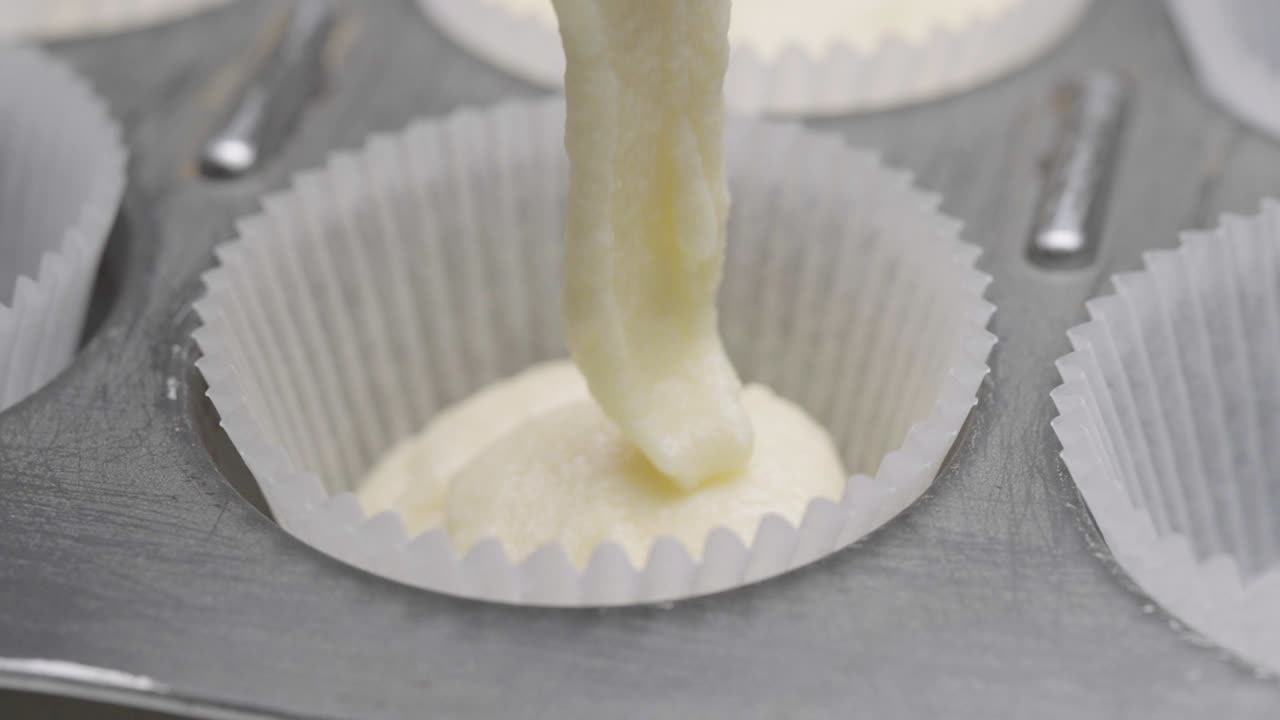 Impasto denso per torta versato in un pirottino per cupcake, con la sua consistenza in primo piano macro