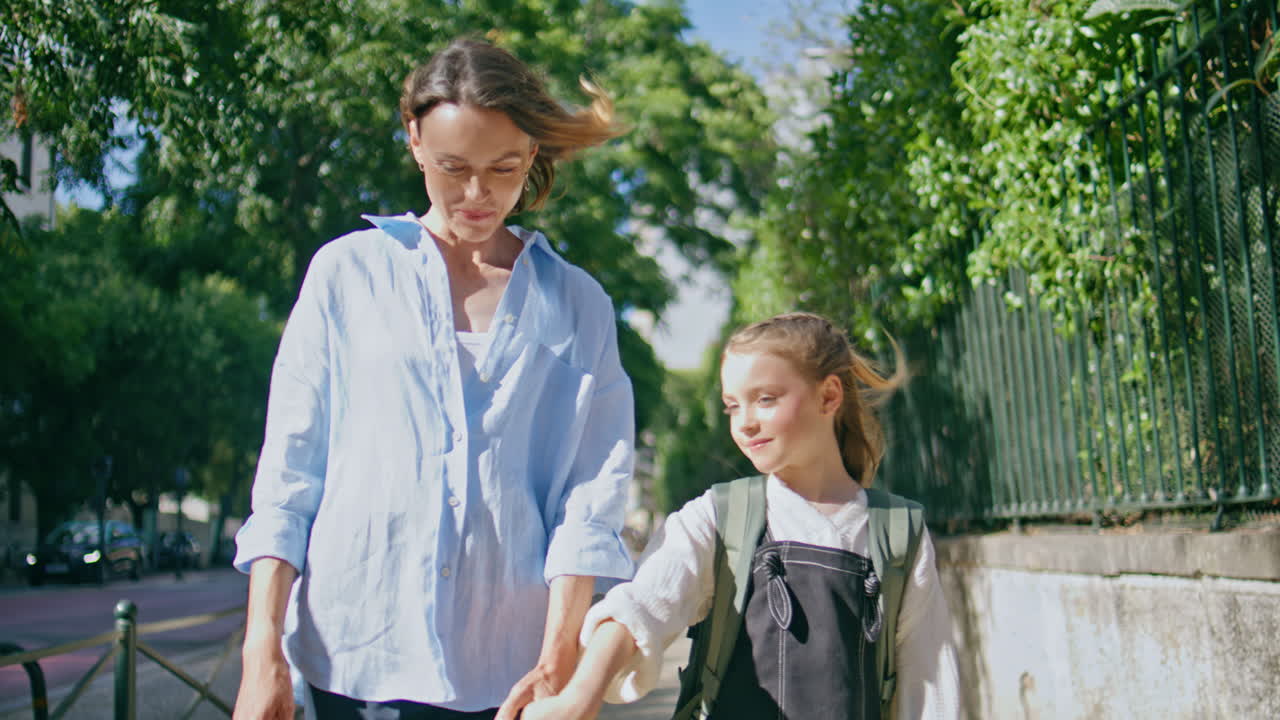 Woman child strolling sunlight calm street communicating. Mother spinning kid