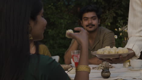friends and family enjoying a meal and dessert at an outdoor gathering