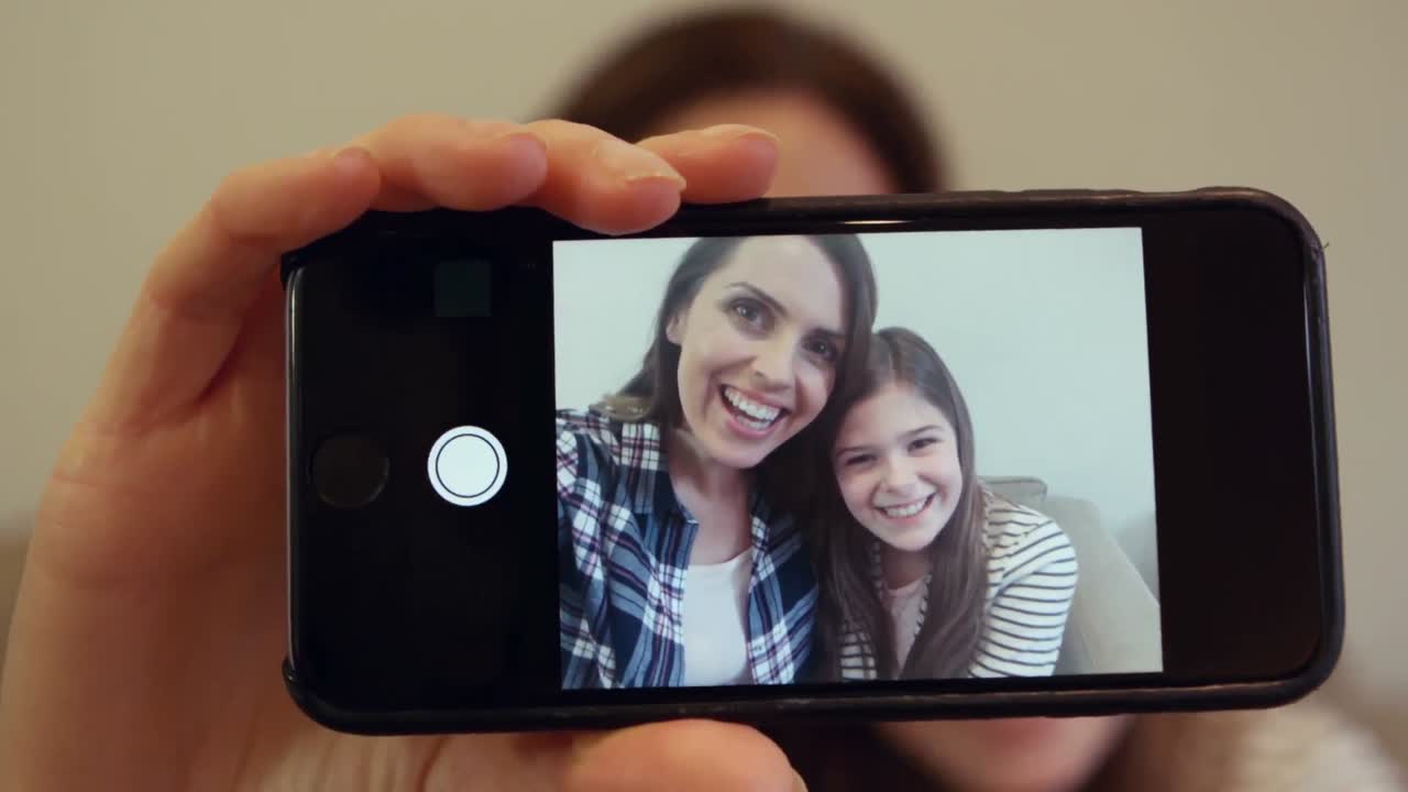 madre haciendo clic en una foto desde el teléfono móvil