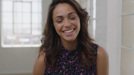 Retrato-En-Cámara-Lenta-De-Una-Atractiva-Joven-Hispana-Riéndose-Alegre-Mirando-La-Cámara-Usando-Una-Hermosa-Blusa-Floral-En-El-Fondo-Del-Apartamento