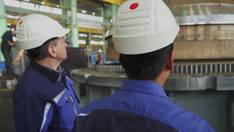 industrial engineers inspecting large machine components