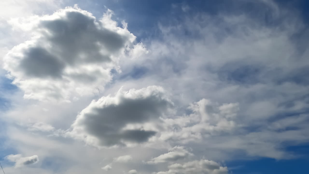 Light soft clouds float in the sky. Cloudscape gathering in the atmosphere. Low angle view. Timelapse.