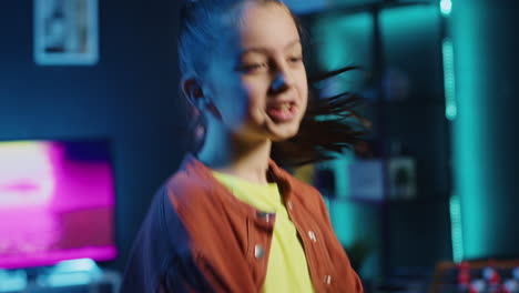 excited child doing viral dance choreography in apartment illuminated by neon lights