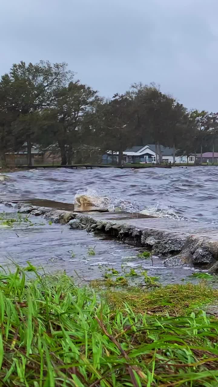 Flood water from hurricane waves smashing against bulkhead and flooding road