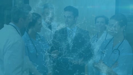 animation of network of connections over caucasian businessman talking to a team of medical doctors