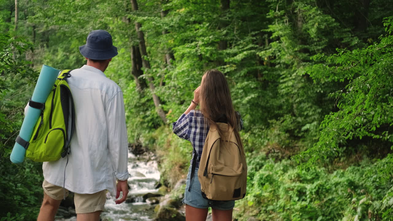 una pareja caminando por el bosque.