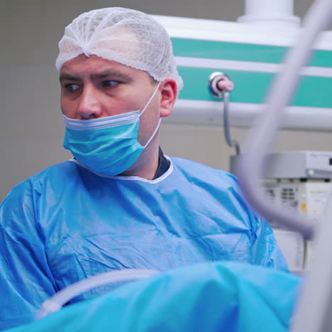 nervous surgeon in the operating room. doctor in blue mask and uniform looking aside during the operation process. medical concept.