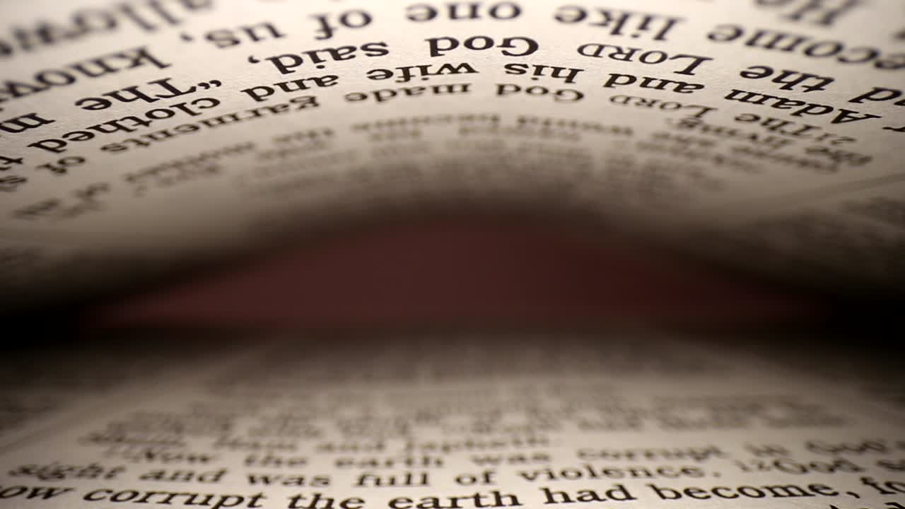 Slowly pulling lens out of a book at a words eye view of the pages, pages on both top - bottom of viewpoint
