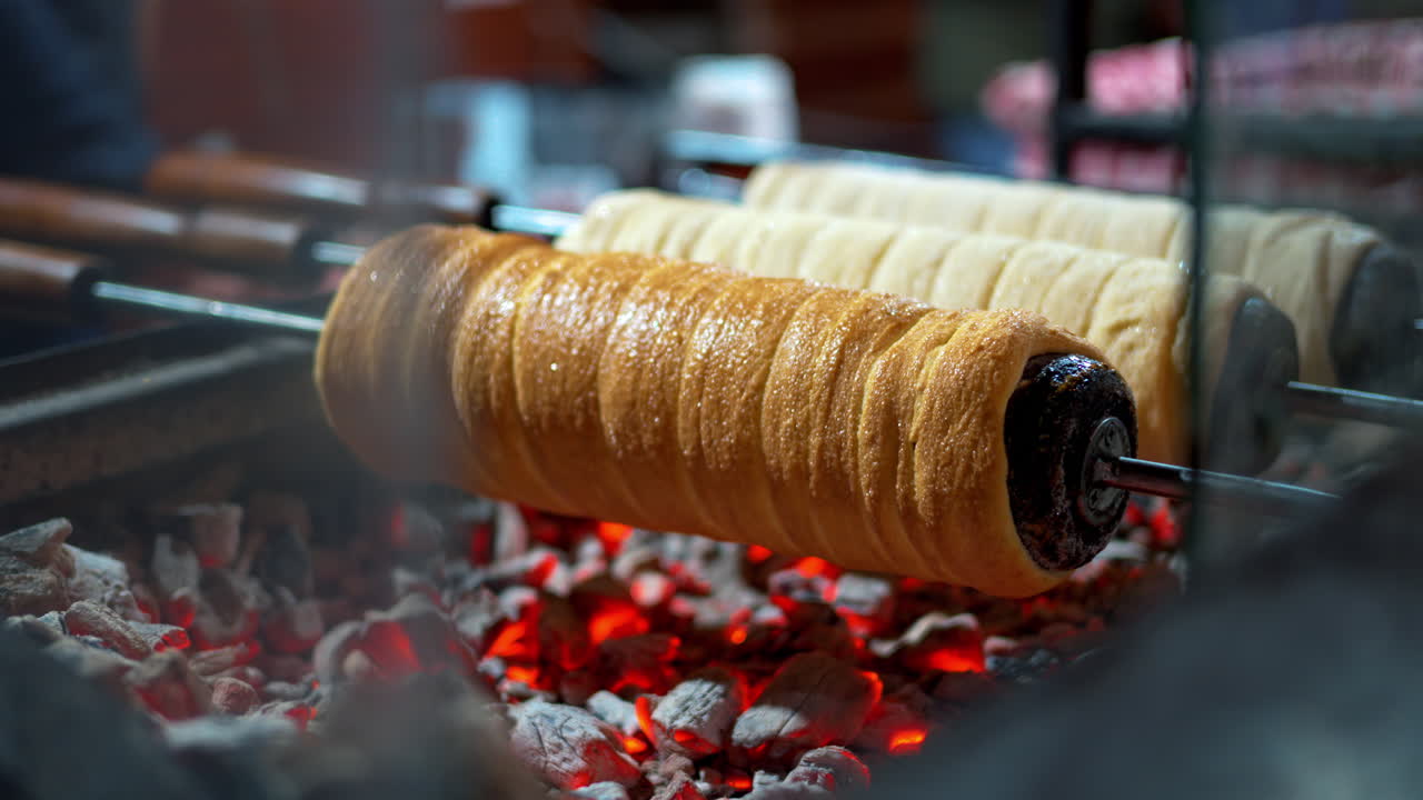 Close up of chimney cakes spinning on smoldering coal
