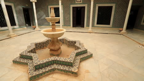 wide-angle shot of an arabic-styled courtyard with a fountain in sbeitla, tunisia