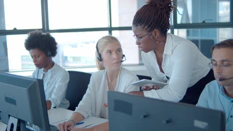 young female manager helping call center employees with the work