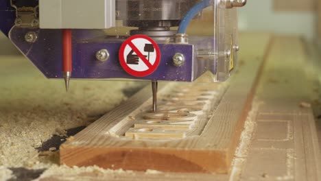 a cnc machine outlining a wooden sign in slow motion in a furniture makers factory