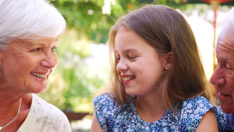 Kids-at-outdoor-cafe-with-their-grandparents,-close-up,-pan