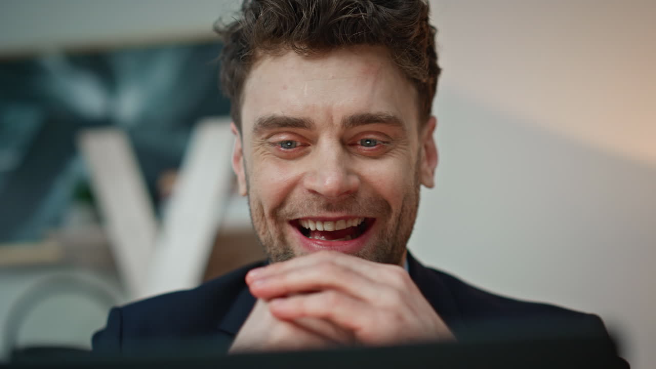 Primo piano di un uomo d'affari entusiasta che guarda lo schermo del laptop, anticipando il successo in ufficio.