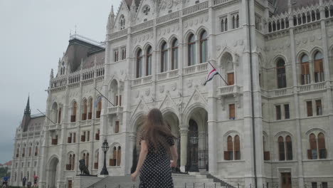 woman running in front of the hungarian parliament building