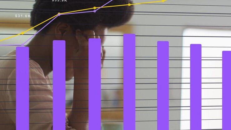 Woman leaning in office with finance charts appearing near her, reaching and analyzing data