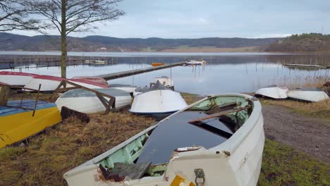 muchos botes de remos atracaron en el agua cerca del lago y algunos se inundaron