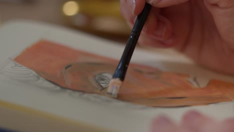 woman painting a female portrait on paper