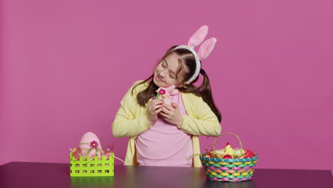 cheerful smiling girl hugging her stuffed rabbit toy and egg