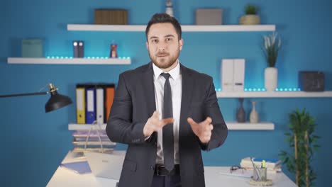 sympathetic businessman smiling and talking at camera.