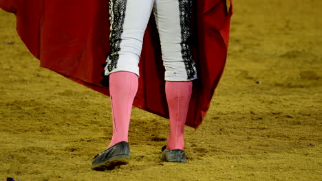 spanish matador walking to the bull inside the arena