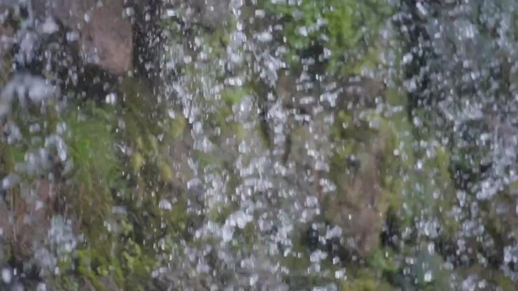 Water streams next to rocky wall
