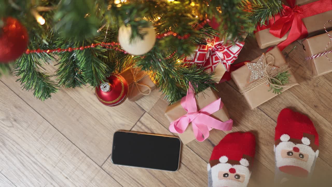telón de fondo de navidad con calcetines divertidos de teléfono inteligente y espacio de copia en el suelo de madera