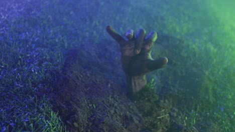 Video-of-hand-raising-from-grass-on-black-background