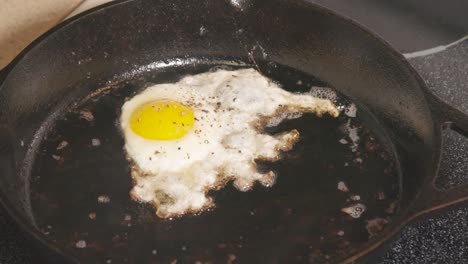 sartén de hierro fundido en estufa freír huevo bordes marrones yema amarilla