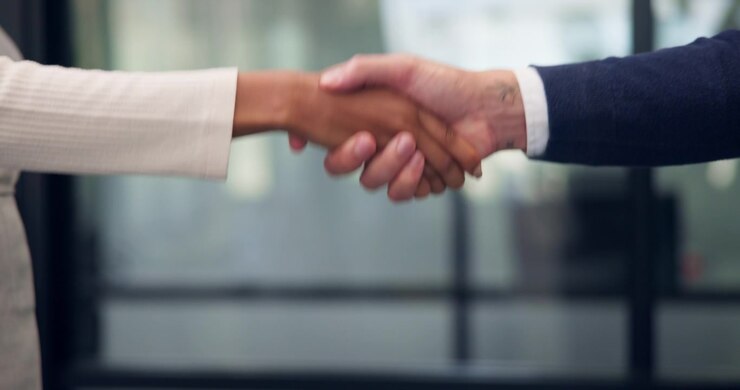 Professionisti d'affari che si stringono la mano in un ufficio moderno