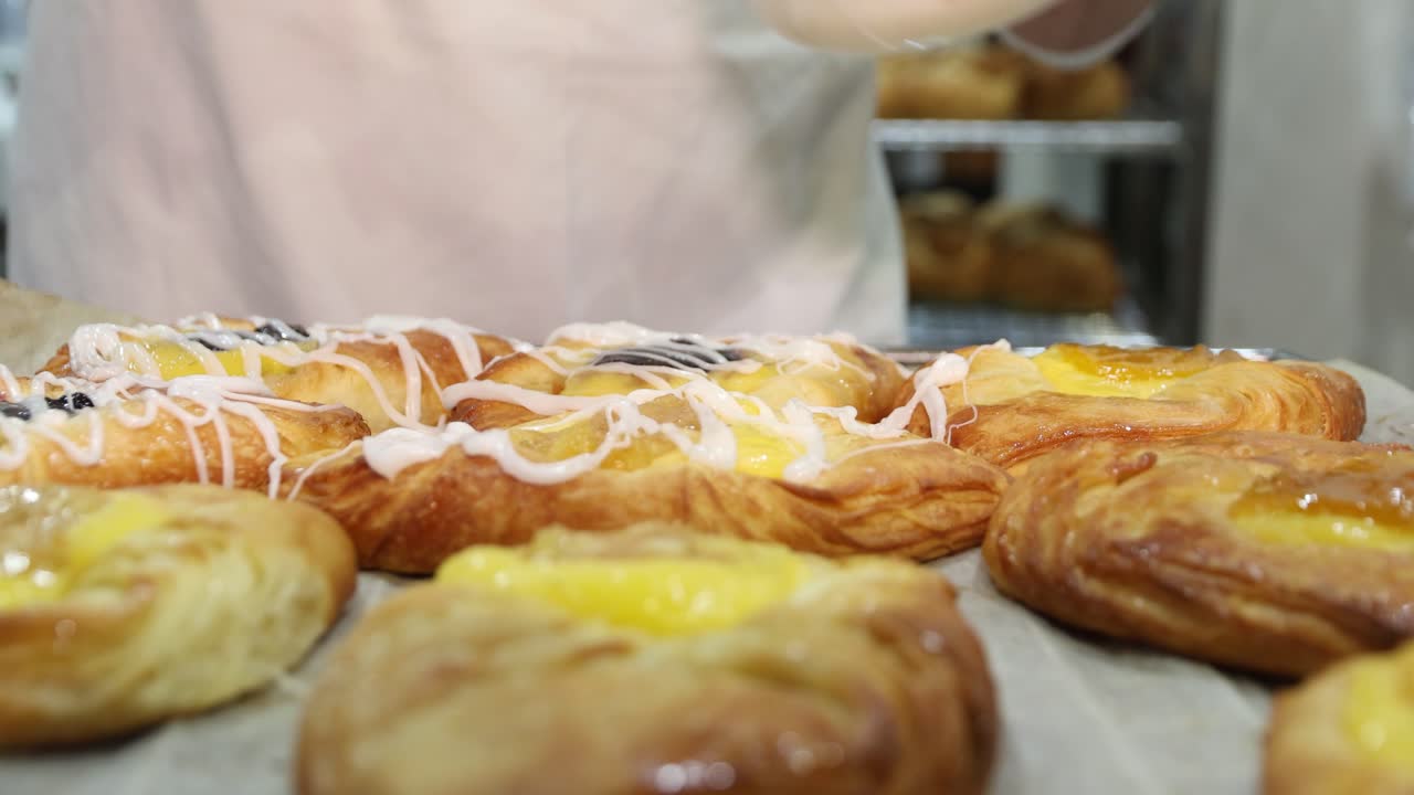 A close-up of pastries being iced at the Farina Underground Bakery. A volunteer adds the finishing touches to these delicious treats in this historic outback location