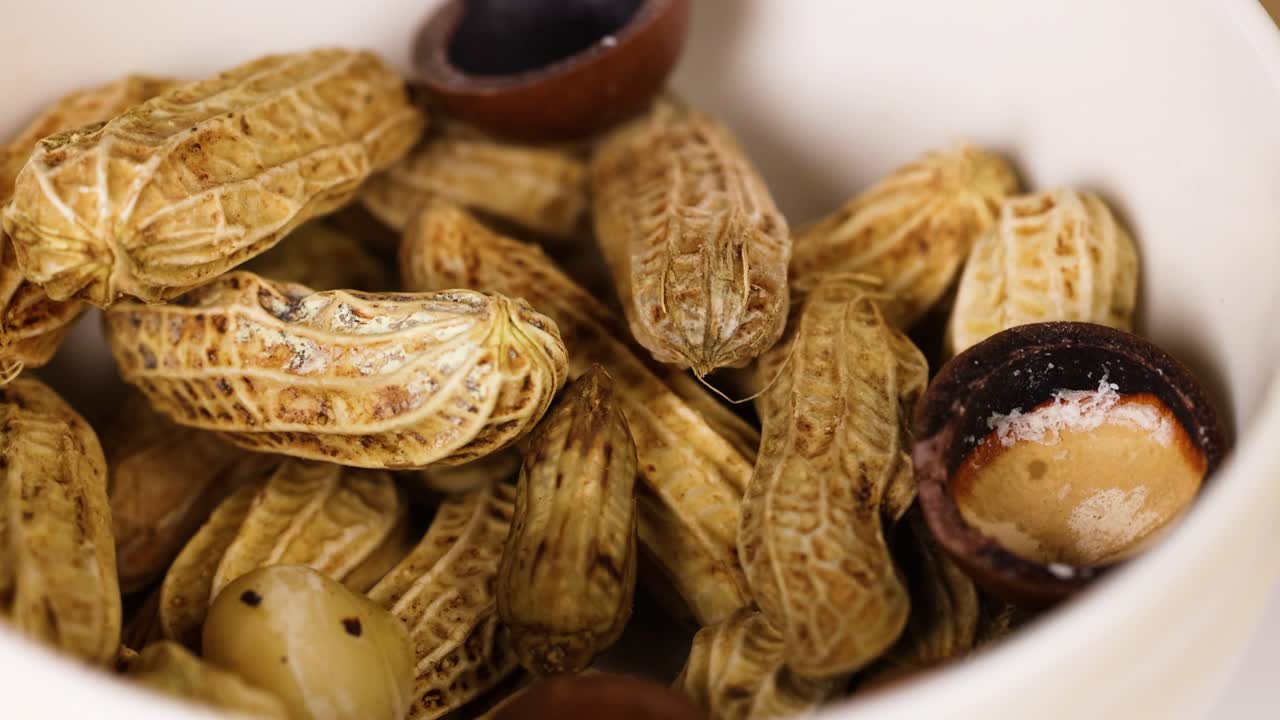 Peanuts and chestnuts arranged in a white bowl
